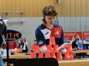 Laura is stacking her red cups at a tournament.